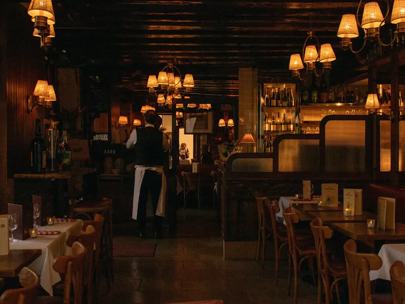 Une salle de pizzeria le soir, lumière tamisée