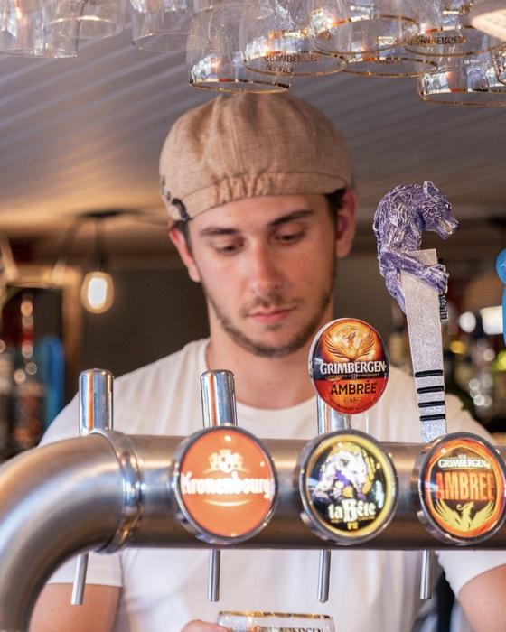 Jules au bar, en train de servir une bière
